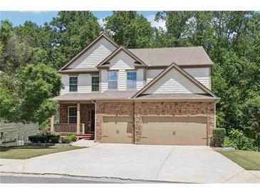 Charming two-story home featuring a stone and siding facade, a two-car garage, and a welcoming front porch at 337 Liberty Dr, Acworth, GA 30102
