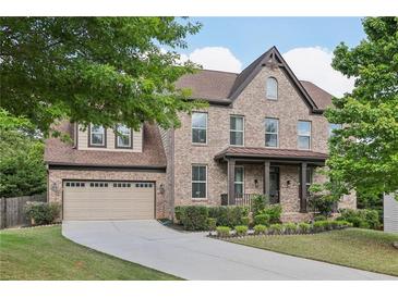 Charming brick two-story home with attached two-car garage and landscaped front yard at 4630 Carriage Walk Ln, Cumming, GA 30040