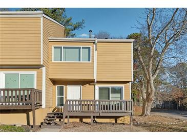 Two-story townhouse with a front porch, tan siding, and well-kept landscaping at 213 Yuba Walk, Lawrenceville, GA 30046