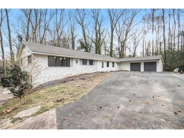 Charming single story brick home with an attached two car garage and long driveway at 5655 Lake Forrest Dr, Atlanta, GA 30342