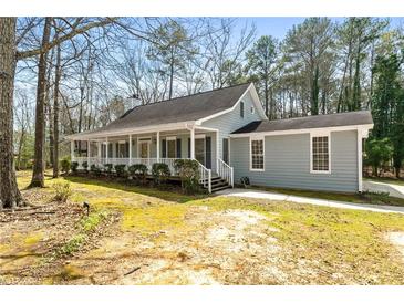 Charming single-story home with a welcoming front porch and mature trees at 195 Willow Way, Stockbridge, GA 30281