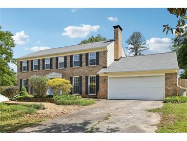 Traditional two-story brick home with attached two-car garage and well maintained yard at 3734 Fox Hills Se Dr, Marietta, GA 30067