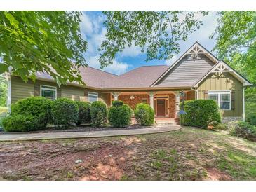 Charming single-Gathering home with stone accents, covered front porch, and mature landscaping at 255 Nicklaus Cir, Social Circle, GA 30025