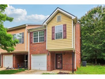 Two-story brick and siding townhome with a one car garage and minimal landscaping at 755 Magnolia Gardens Walk, Mcdonough, GA 30253