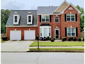 Charming brick home with a well-manicured lawn and a two-car garage at 3703 Liberty Sw Dr, Powder Springs, GA 30127