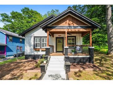 Charming home with a welcoming front porch, modern black and white paint scheme, and inviting curb appeal at 958 Crew Sw St, Atlanta, GA 30315