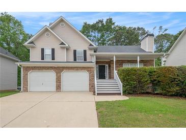 Charming two-story home featuring a two-car garage, stone accents, and a welcoming front porch at 5975 Tate Dr, Austell, GA 30106