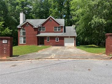 Charming two-story brick home with a well-maintained front yard and a spacious driveway at 6848 Timberhead Way, Lithonia, GA 30058