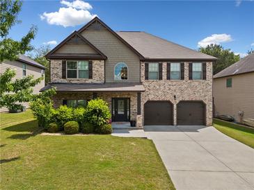 Charming two-story brick home with a well-manicured lawn and a two-car garage at 1314 Bentley Estates Dr, Dacula, GA 30019