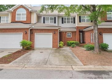 Attractive brick townhome featuring an attached garage, well maintained landscaping, and inviting curb appeal at 59 Townview Dr, Alpharetta, GA 30022