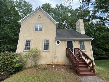 Charming exterior view of home, featuring a unique design, inviting front entry, and mature landscaping at 4911 Hairston Pl, Stone Mountain, GA 30088