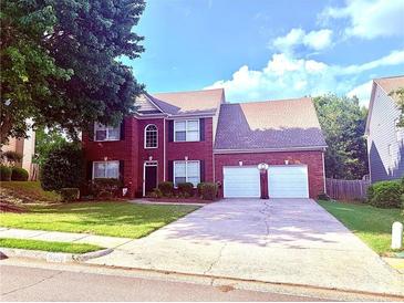 Traditional two-story brick home with a two-car garage and well-maintained landscaping at 6005 Baywood Dr, Roswell, GA 30076