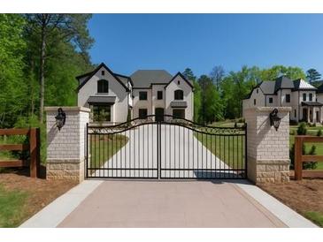 Stunning two-story home with black metal gate and pristine landscaping at 10765 Shallowford Rd, Roswell, GA 30075