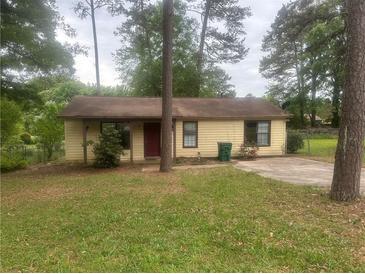 Charming single-story home featuring yellow siding, mature trees, and a well-maintained front yard at 1253 Todiway Ct, Jonesboro, GA 30238