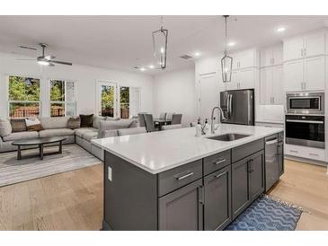 Modern kitchen with an island, stainless steel appliances, and an open concept to the dining and living room at 1070 Harper Dr, Alpharetta, GA 30076