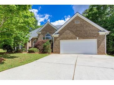 Charming brick home with a two-car garage and a well-manicured front yard beneath a blue sky at 3314 Dilmus Dr, Powder Springs, GA 30127