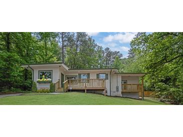 Beautiful house with a front porch, surrounded by mature trees and lush landscaping at 1839 Belcher Pl, Austell, GA 30168