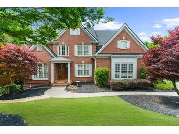 Charming brick home with lush landscaping, mature trees, and a well-manicured lawn at 2135 Glenfield Trce, Cumming, GA 30041