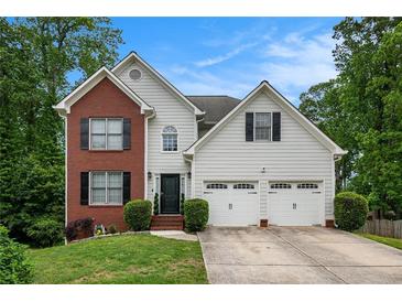 Charming two-story home with a brick accent, attached two car garage, and a well-manicured lawn at 3073 Hopeland Dr, Powder Springs, GA 30127
