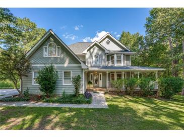 Charming two-story home with a welcoming front porch and well-manicured lawn and mature trees at 558 Auburn Rd, Auburn, GA 30011