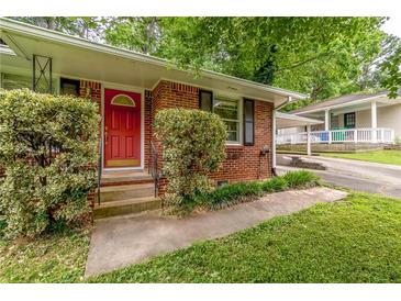 Charming brick home with a bright red front door and mature landscaping at 1145 Arbordale Dr, Decatur, GA 30033