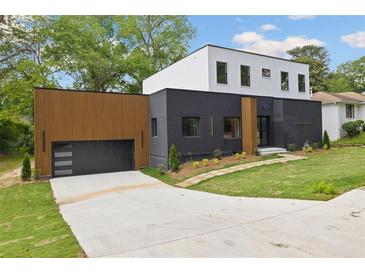 Modern two-story home featuring a black brick facade, wood paneled garage, and a well-manicured front yard at 223 Altoona Sw Pl, Atlanta, GA 30314