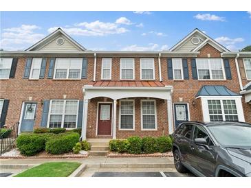 Charming brick townhome with well-maintained landscaping and covered entryway at 274 Paden Cove Trl, Lawrenceville, GA 30044