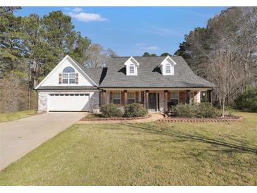 Charming single-story home with brick and siding exterior, well-manicured lawn, and attached garage at 950 Besse Way, Locust Grove, GA 30248