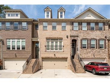 Charming brick townhome with attached garage and inviting front entrance, offering a blend of classic design and modern living at 2122 Pembroke Dr, Brookhaven, GA 30319