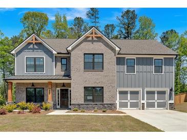 Charming two-story home features a combination of brick and gray siding, complemented by a well-manicured front lawn at 4720 Cooling Water Sw Cir, Powder Springs, GA 30127