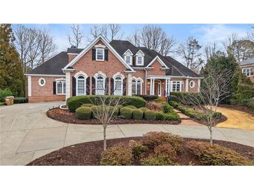 Elegant brick home with manicured landscaping and circular driveway at 5560 Stoneleigh Dr, Suwanee, GA 30024