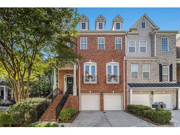Charming brick townhome with an inviting entrance and two-car garage, offering modern comfort and curb appeal at 3025 Woodwalk Se Dr # 17, Atlanta, GA 30339