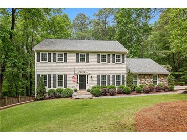 Charming two-story home with grey shake siding, black shutters, and a lush green lawn at 410 Dalrymple Ne Rd, Atlanta, GA 30328