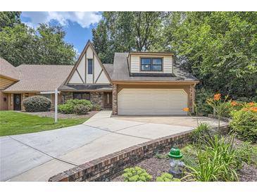 Charming Tudor-style home with a well-manicured lawn, brick accents and attached two-car garage at 12 Westchester Square Sq, Decatur, GA 30030