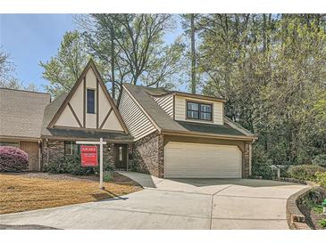 Charming Tudor-style home featuring a two-car garage, brick facade, and well-manicured landscaping at 12 Westchester Square Sq, Decatur, GA 30030