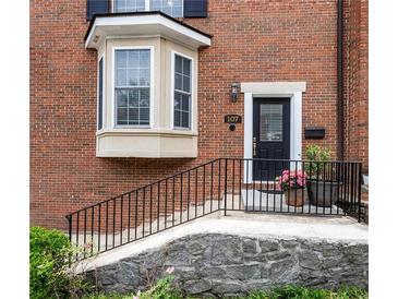 Charming brick home featuring a bay window, black door, and inviting front entrance with manicured landscaping at 1634 Ponce De Leon Ave # 107, Atlanta, GA 30307