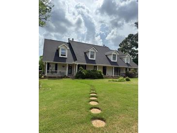 Inviting exterior with dormer windows, lush green lawn, and stepping stone walkway at 905 Park Ne Pl, Conyers, GA 30012