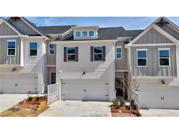 Charming townhome featuring a clean white facade, two-car garage and decorative shutters at 1297 Fern Ridge Ct # 24, Norcross, GA 30093