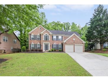 Charming two-story brick home featuring a well-manicured lawn and a two-car garage at 1465 Laleiah Dr, Cumming, GA 30041