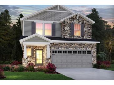 Charming two-story home with stone and siding, showcasing a well-manicured lawn and inviting two-car garage at 5115 Abdulla Dr, Cumming, GA 30041