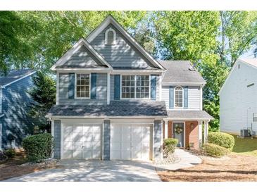 Charming two-story home with a two-car garage, fresh landscaping, and delightful blue shutters at 3253 Strathmore Dr, Duluth, GA 30096