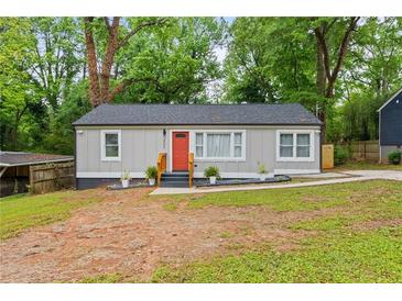 Charming single-story home with a fresh gray exterior, bright orange door, and well-maintained landscaping at 3566 Orchard Dr, Decatur, GA 30032