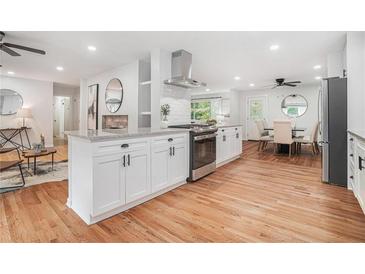 Bright, modern kitchen features granite countertops, white cabinets, and stainless steel appliances at 4807 Kenilworth Dr, Stone Mountain, GA 30083