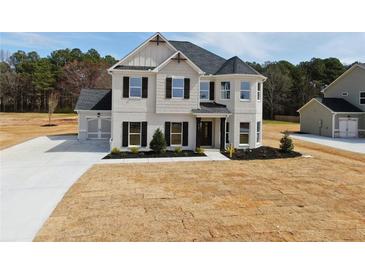 New construction home with light gray brick, shutters, manicured landscaping, and a side entry garage at 3154 Rosebud Rd, Loganville, GA 30052