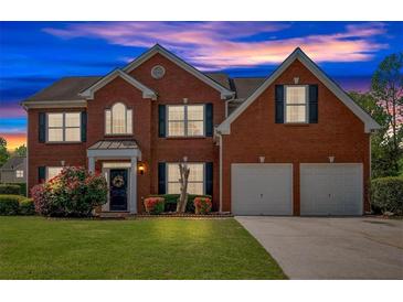 Charming two-story red brick home with a well-manicured lawn and attached two car garage at 3477 Seneca Farm Dr, Buford, GA 30519