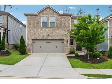 Charming two-story brick home with a well-manicured front yard and an attached two-car garage at 4777 Waxwing St, Hoschton, GA 30548