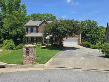 Charming two-story brick home with a well-manicured lawn and inviting curb appeal at 345 Oak Springs Nw Dr, Lawrenceville, GA 30043
