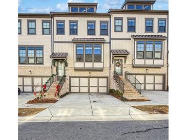 Charming townhomes featuring brick accents, individual garages, and inviting staircases at 1127 Provence Ln, Decatur, GA 30033