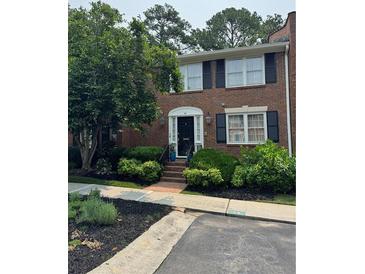 Charming brick townhome entrance with manicured landscaping and inviting walkway at 4620 Wieuca Ne Rd # 42, Atlanta, GA 30342