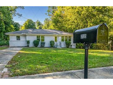 Charming white brick home with a well-manicured front lawn and mailbox at 2135 Niskey Lake Sw Rd, Atlanta, GA 30331